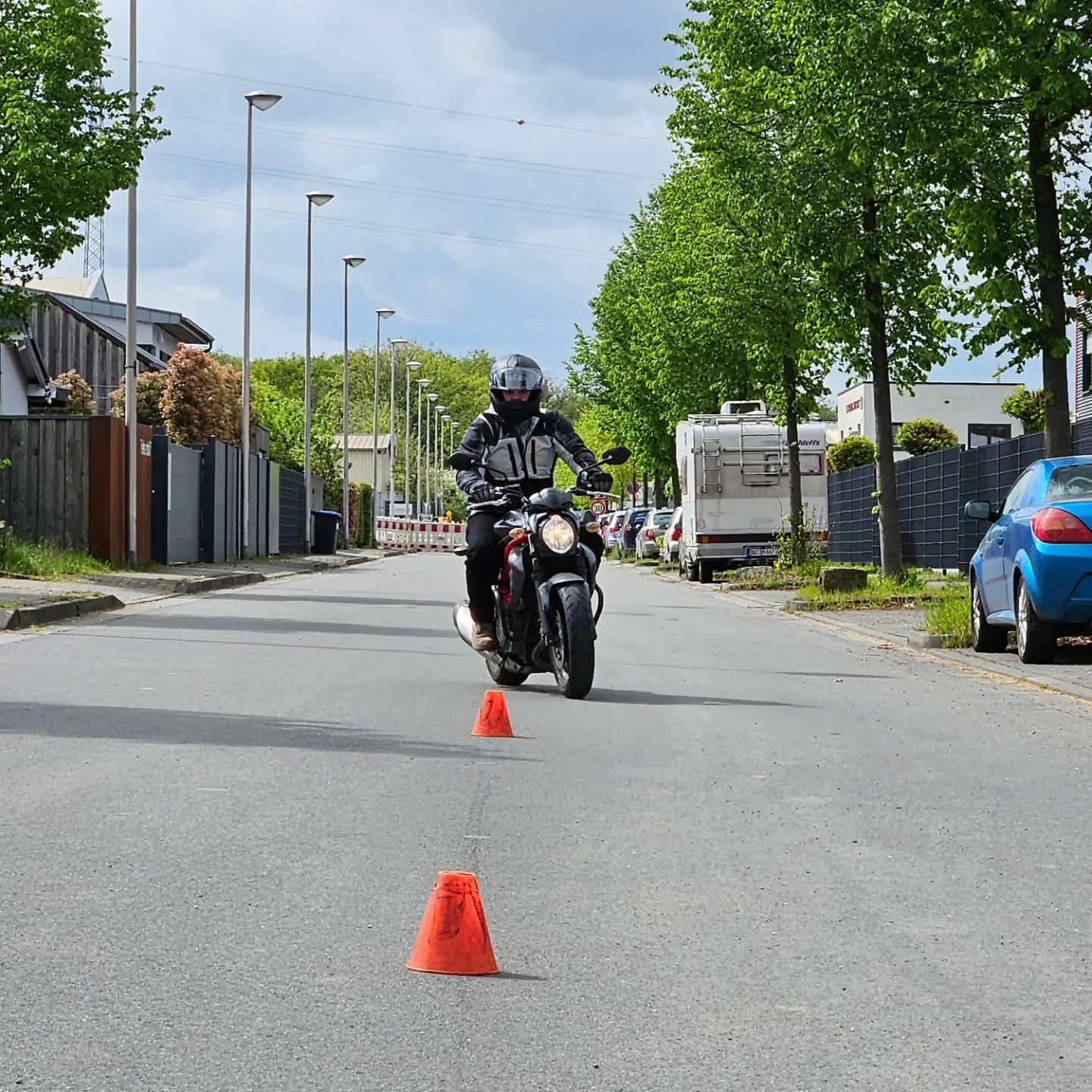 Motorradausbildung, auf einer abgelegenen Straße, Hütchen aufgestellt, um die der Fahrschüler drumherum fahren muss